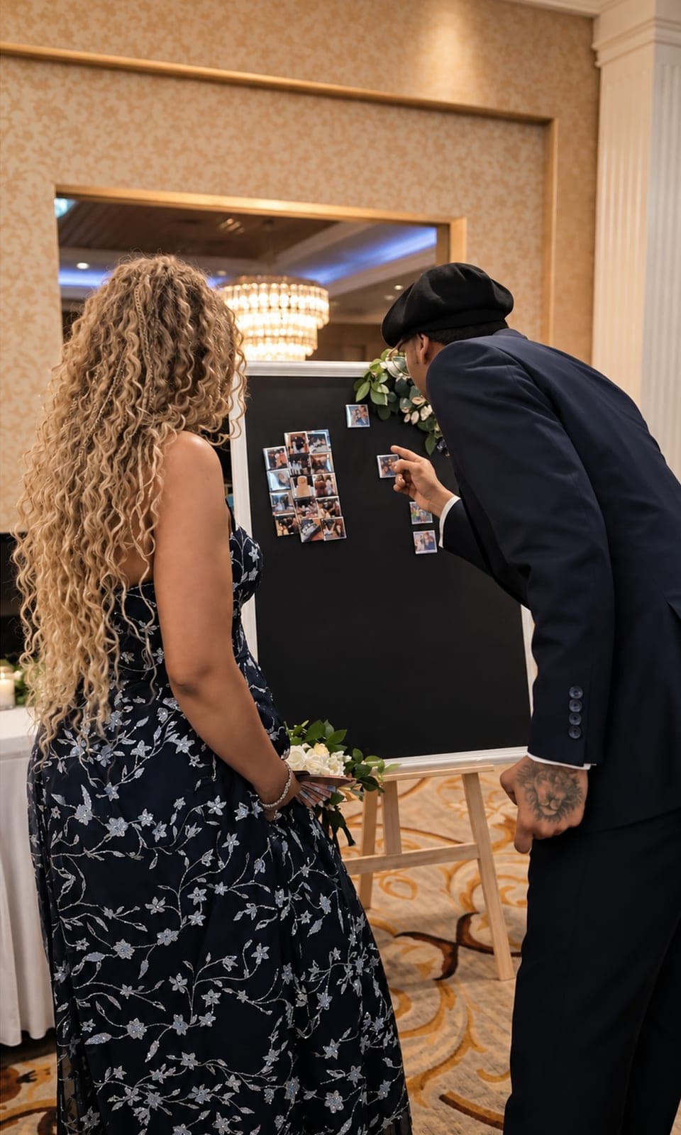 Wedding guests pointing at photo magnets on the Memory Board in a ballroom
