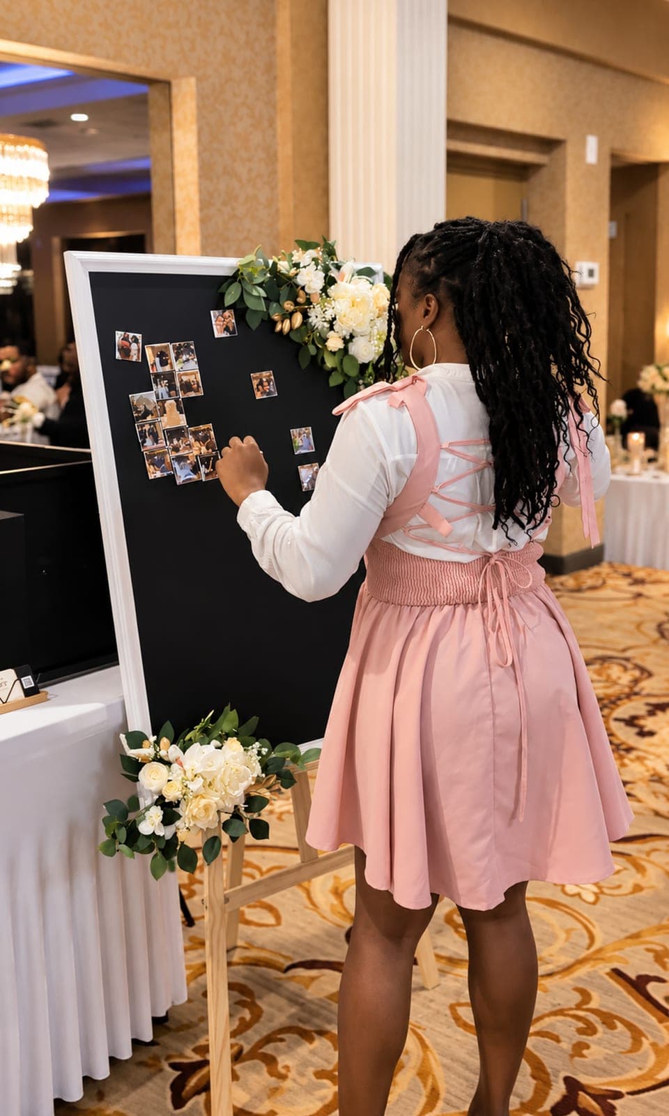 Wedding guest placing her photo magnet on the flower-trimmed Memory Board