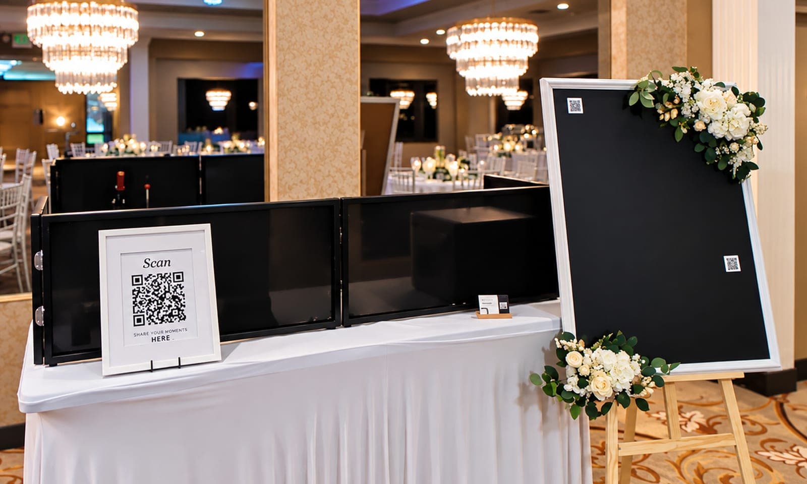 The Tender Kept magnet station: skirted table, QR scan sign, printer screens, and the Memory Board on an easel in a ballroom